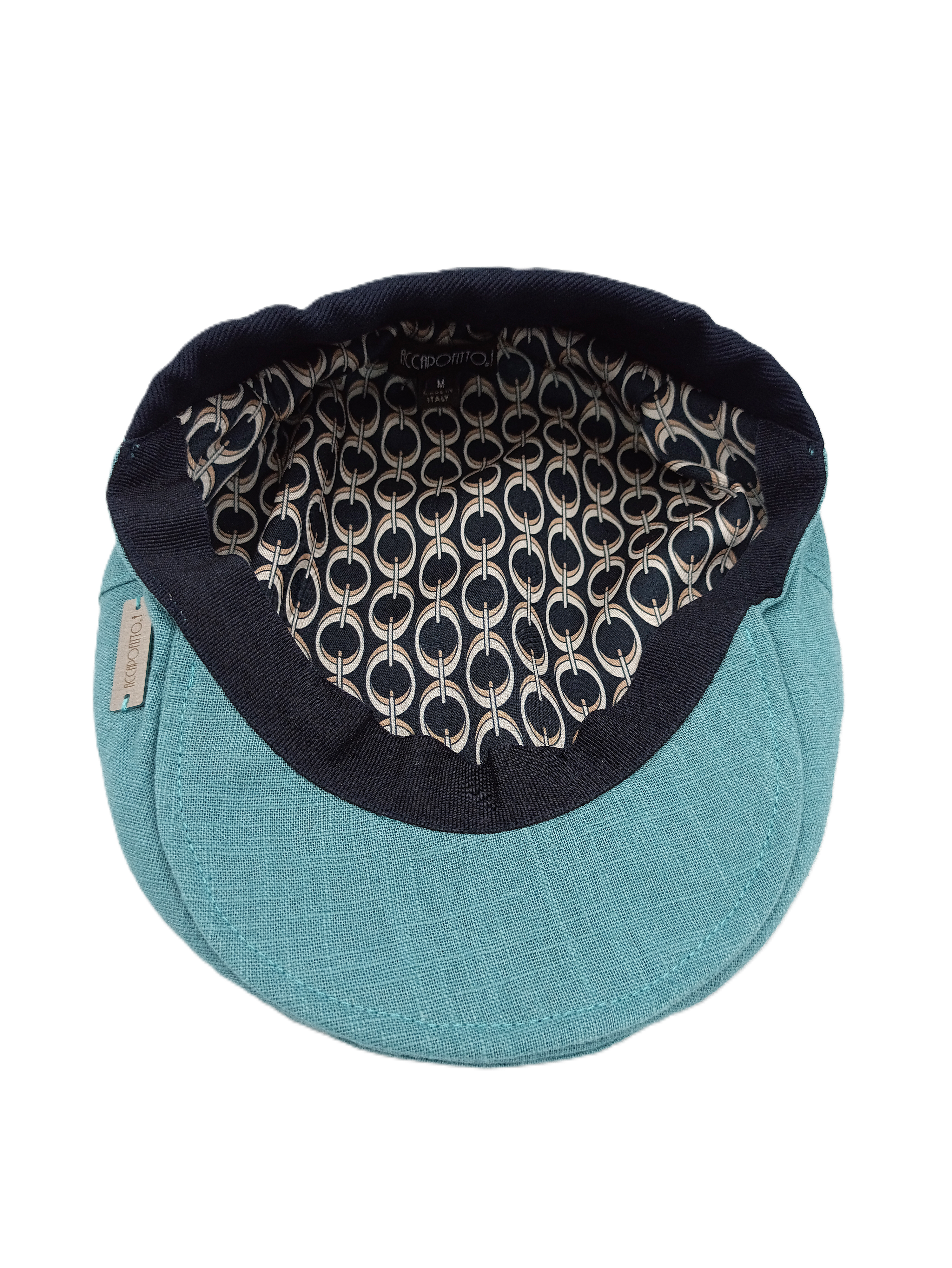 Coppola unisex in puro lino color acqua del brand Accapofitto. Visione della fodera interna con fantasia anelli beige su sfondo blu