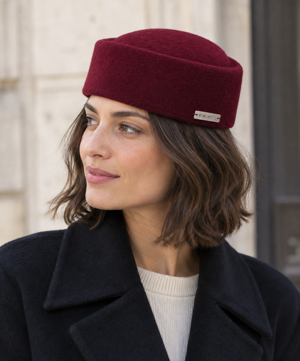 Cappello pillbox Chèrie del brand Accapofitto, in morbido feltro di lana color bordeaux e targhetta con logo, indossato da una modella