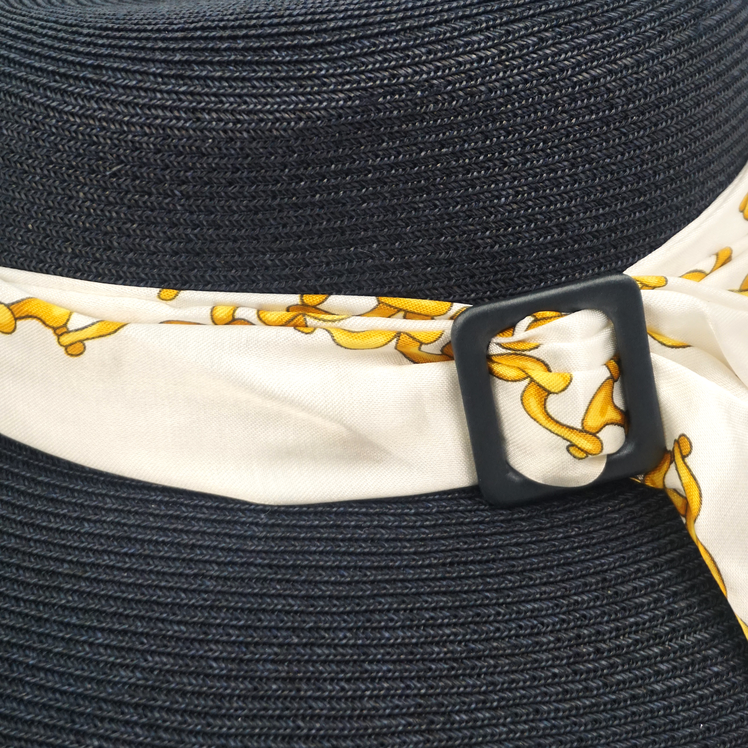 Cappello elegante di carta colore blu, decorato con foulard bianco e disegni oro, con fibbia blu
