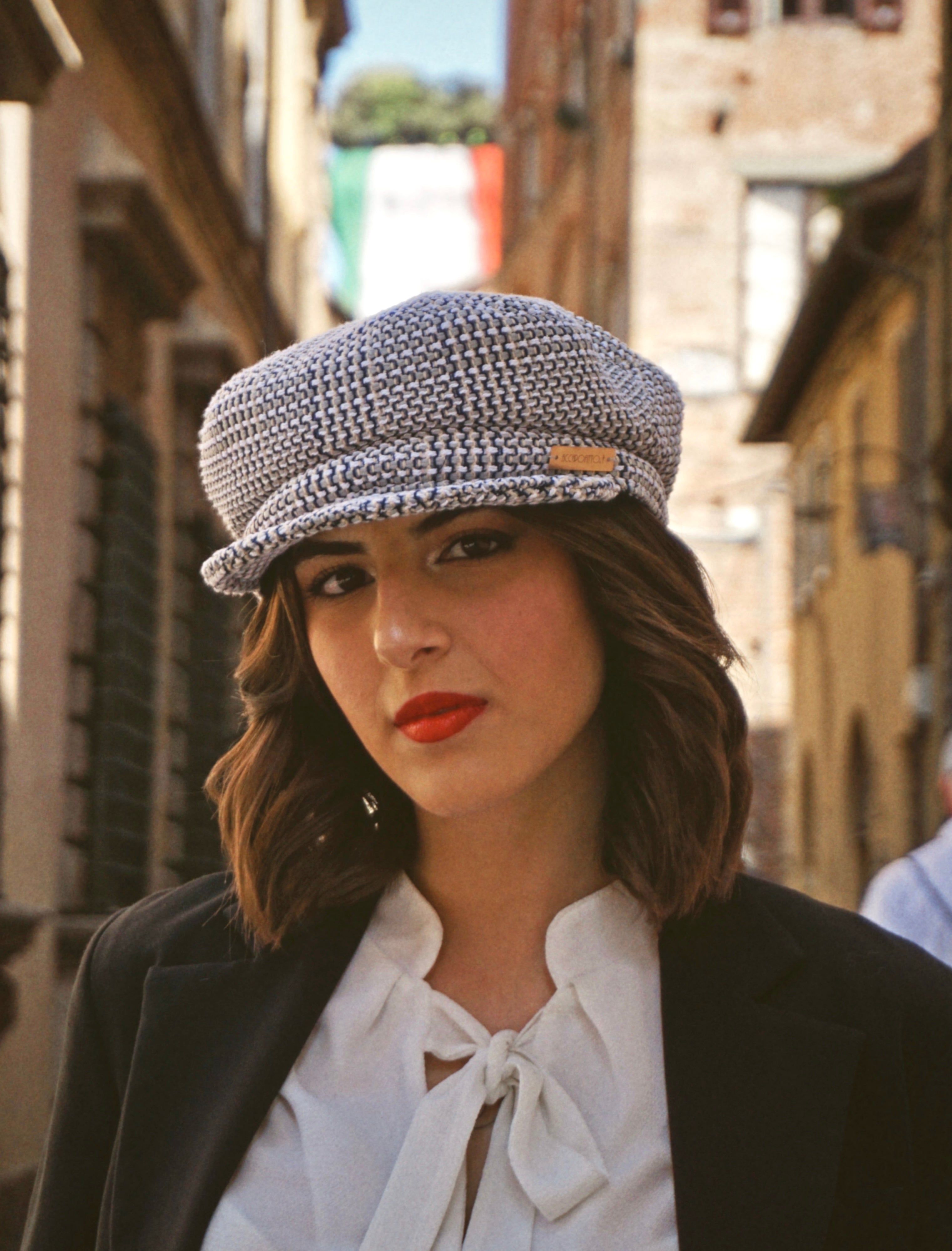 Cappello sailor hat del brand Accapofitto, con tessuto intrecciato sui toi del beige e del blu, targhetta dorata con logo. Indossato dalla modella