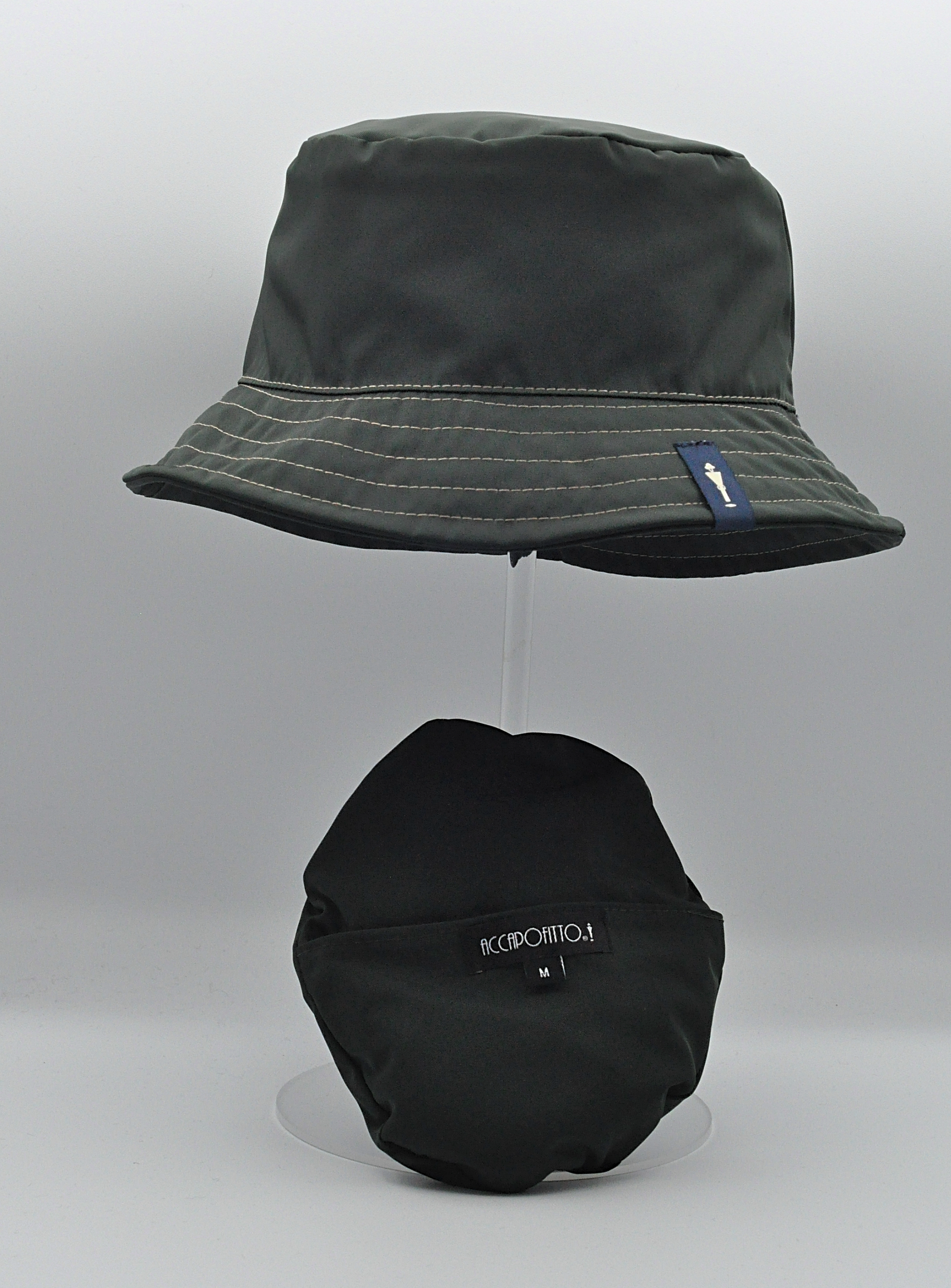 Cappello impermeabile del brand Accapofitto, ripiegabile. Colore verde scuro con rifiniture beige. Visione d'insieme