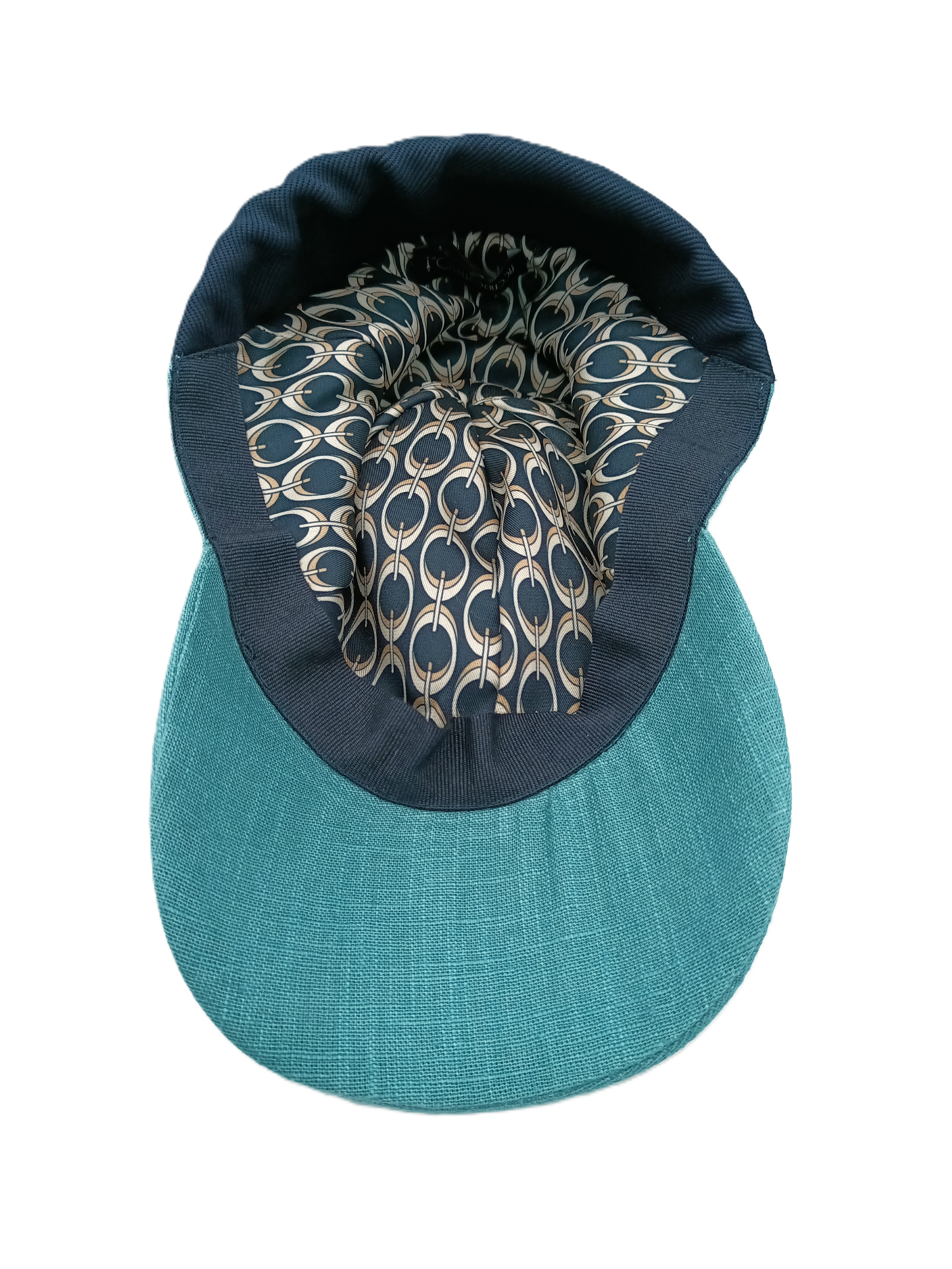 Cappello baseball lino color acqua del brand Accapofitto, con inserto in jersey elasticizzato blu sulla nuca. Visione della fodera interna, fantasia anelli beige si sfondo blu