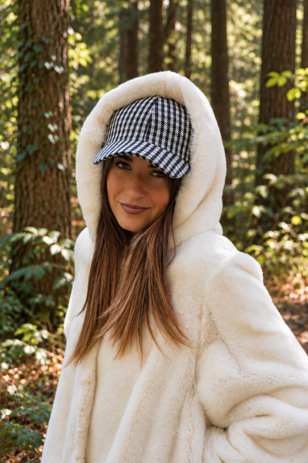 Cappello baseball a 6 spicchi Bry del brand Accapofitto, in tessuto a quadretti blu e grigio, indossato da una modella sotto una pelliccia bianca