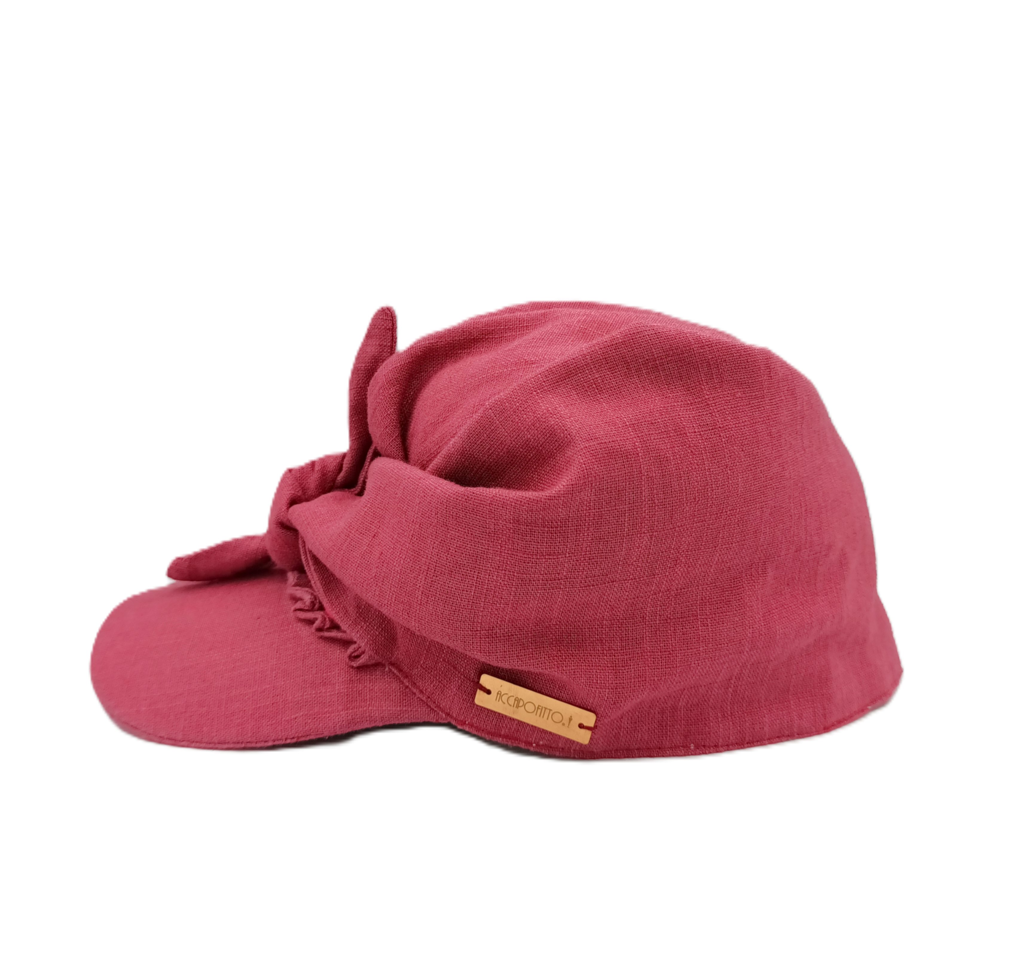 Cappello baseball di lino color lampone, con nodo sul davanti del brand Accapofitto. Visione laterale con targhetta color rame
