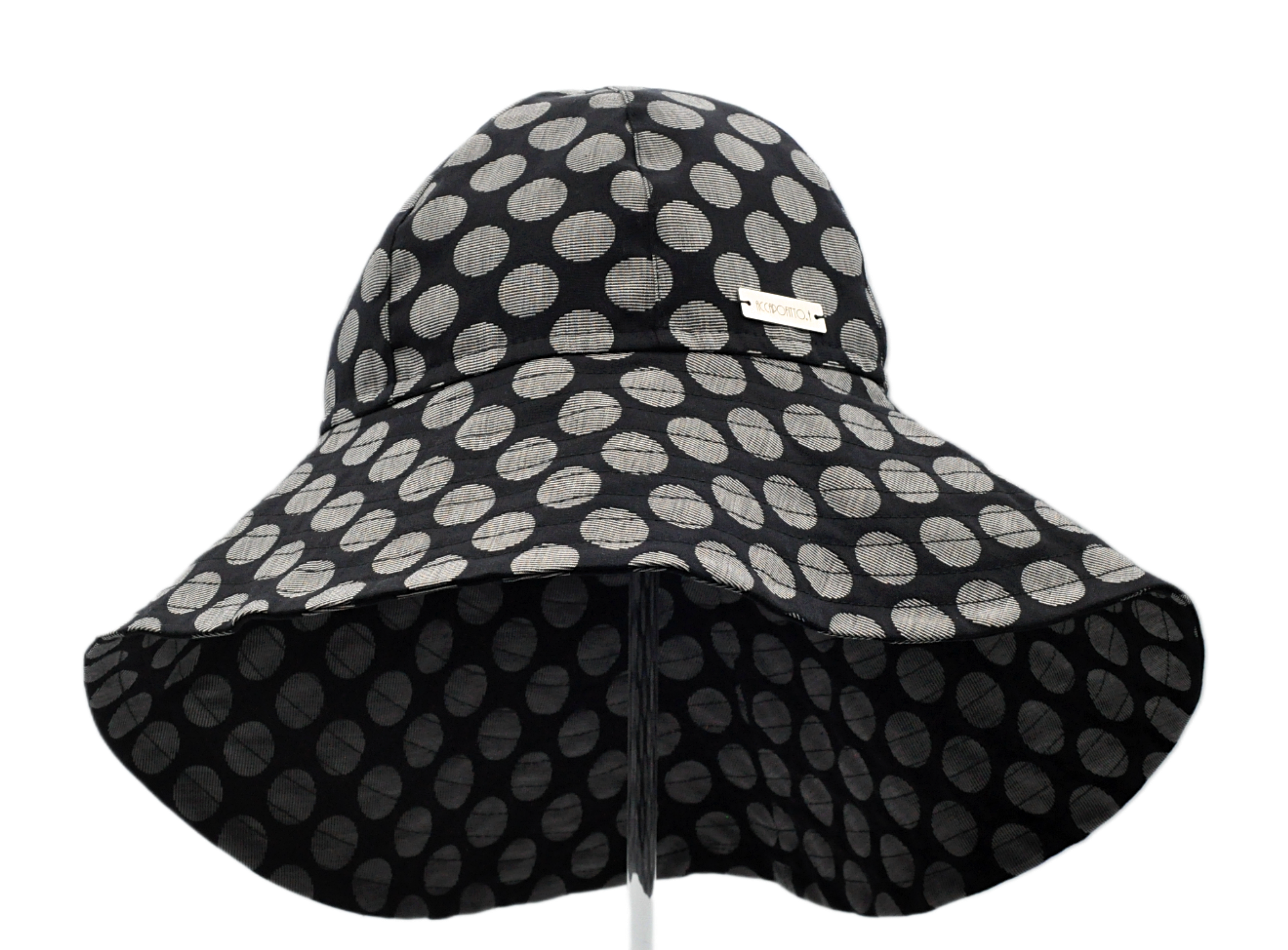 Cappello a cloche del brand Accapofitto, con tesa molto ampia sul collo. Fantasia sfondo nero e pois grandi chiari