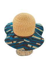 Carica l&#39;immagine nel visualizzatore di Gallery, Visione del retro del cappello Romance modello Pamela con capino in paglia e tesa in tessuto misto rafia di viscosa con fantasia a strisce beige, marroni e blu cobalto
